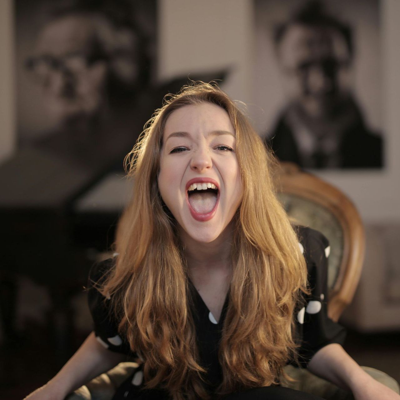A woman is sitting in a chair with her mouth open