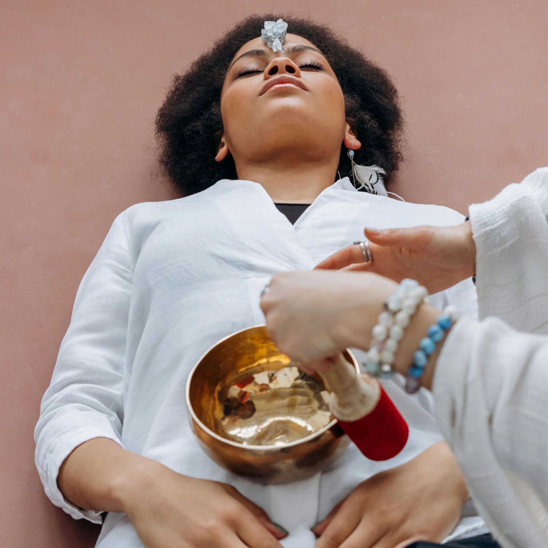 A woman is laying down with a bowl on her stomach.