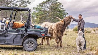 A truck is parked in a field with trees in the background.