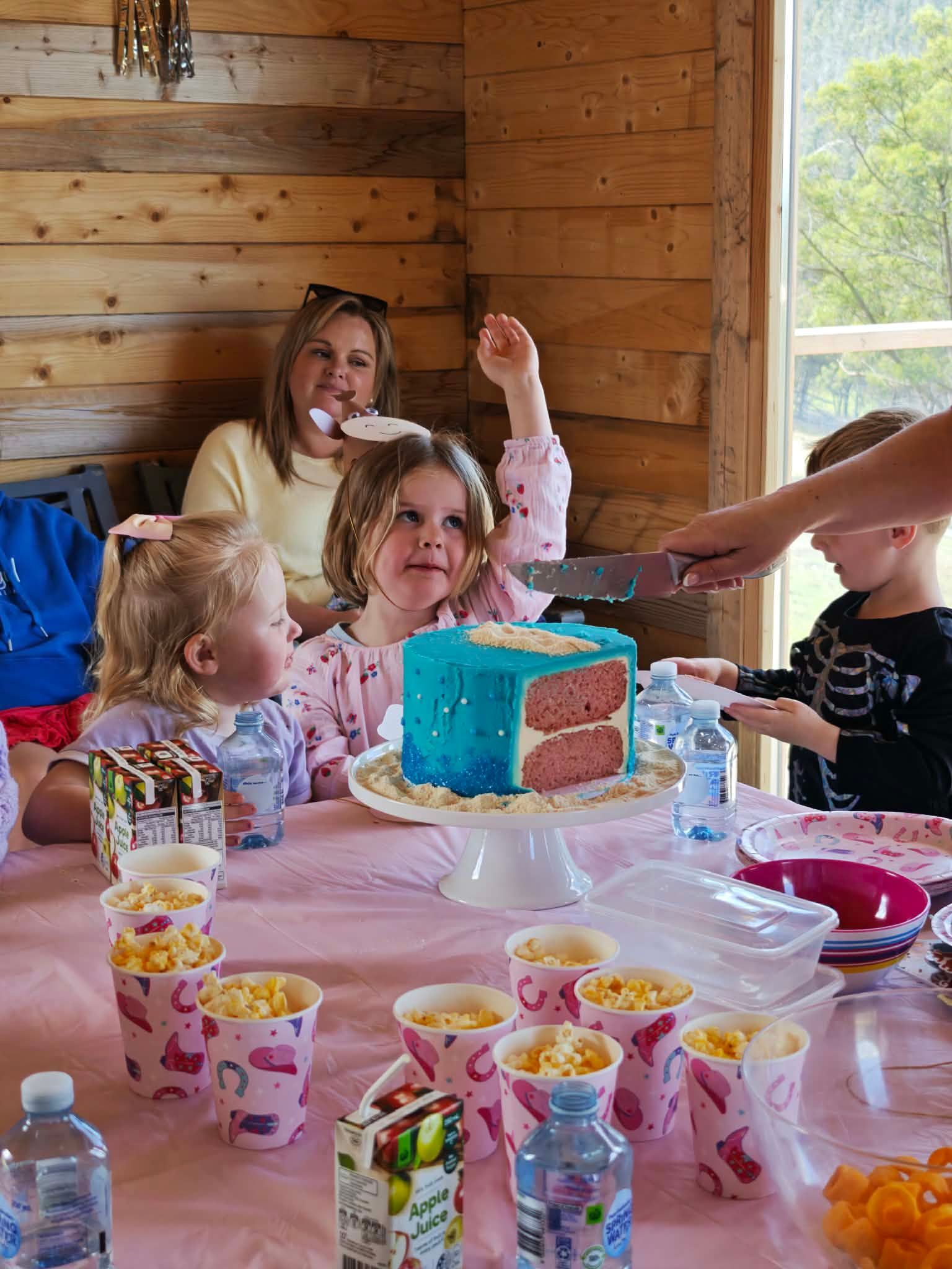 A man is feeding a calf from a bottle in a field.