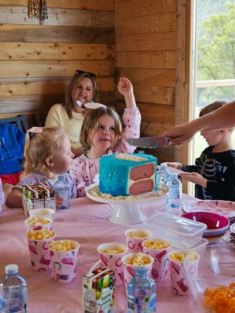 A man is feeding a calf from a bottle in a field.