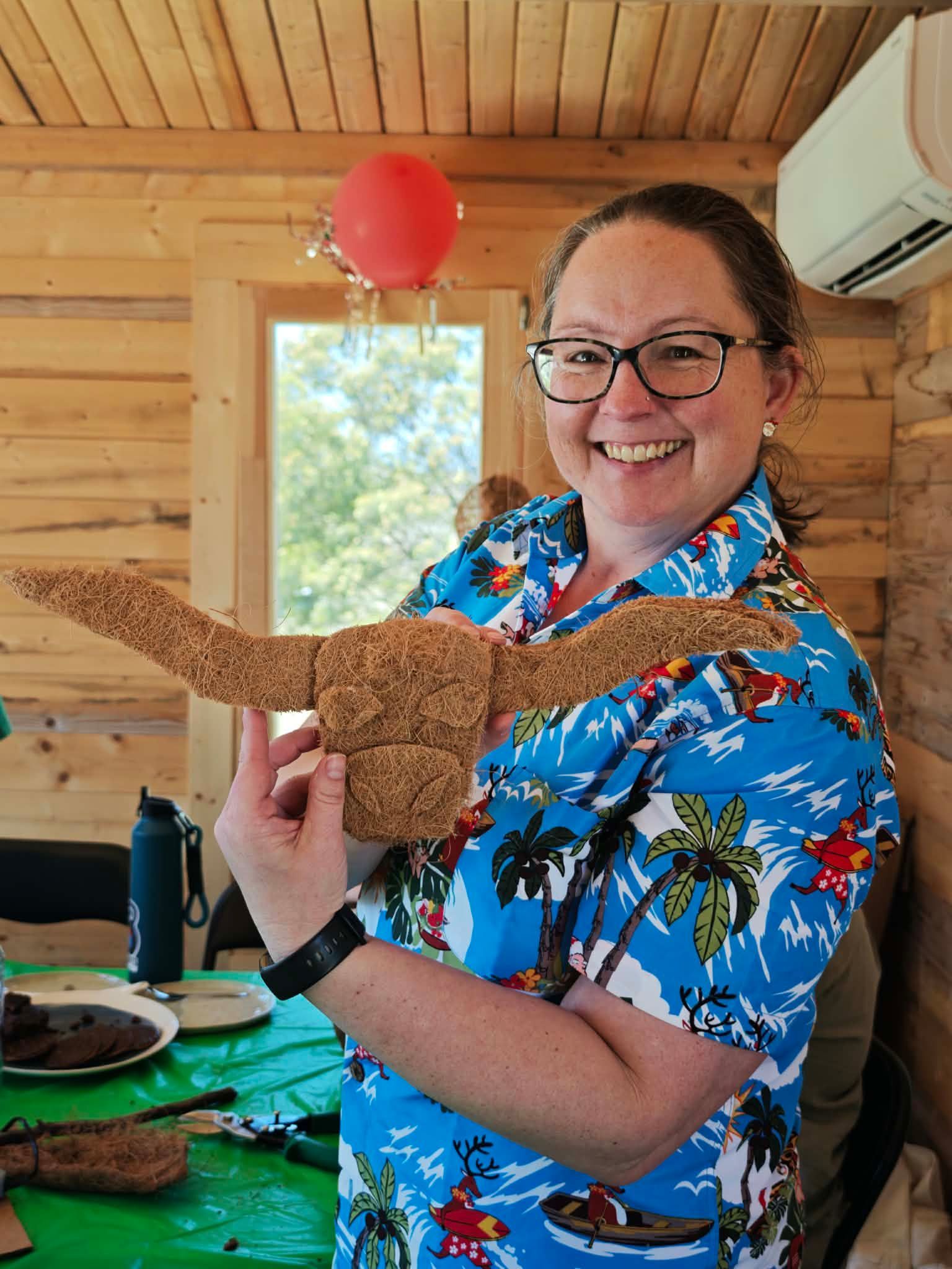 A woman is petting a baby cow in a field.