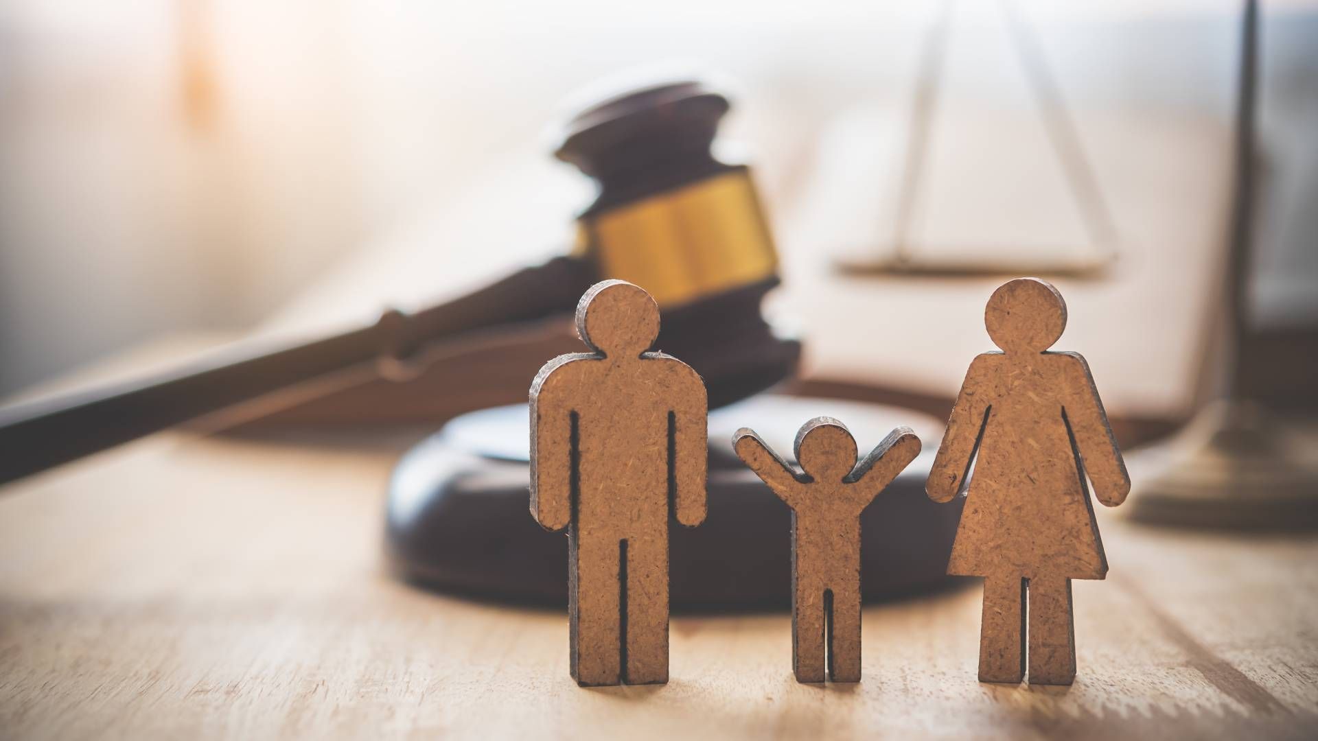 A wooden family is standing in front of a judge 's gavel.