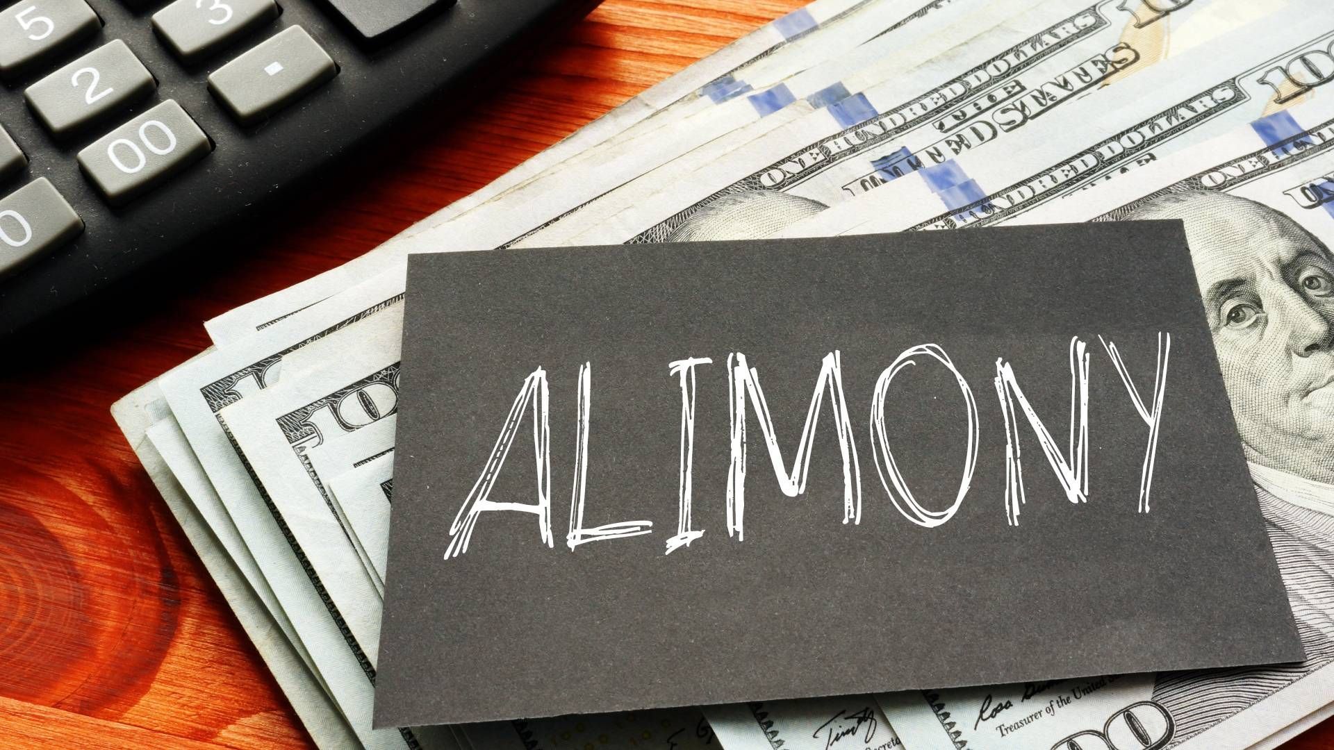 A stack of money next to a sign that says alimony