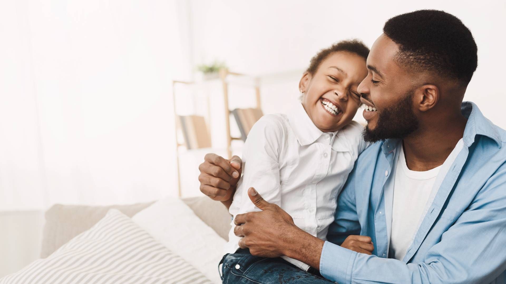 A man and a little girl are sitting on a couch.