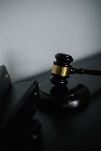A judge 's gavel is sitting on top of a black table.