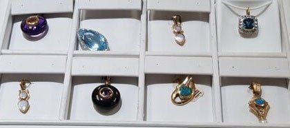 A display case filled with a variety of pendants