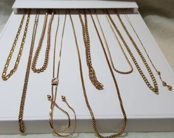 A bunch of gold chains are displayed on a table