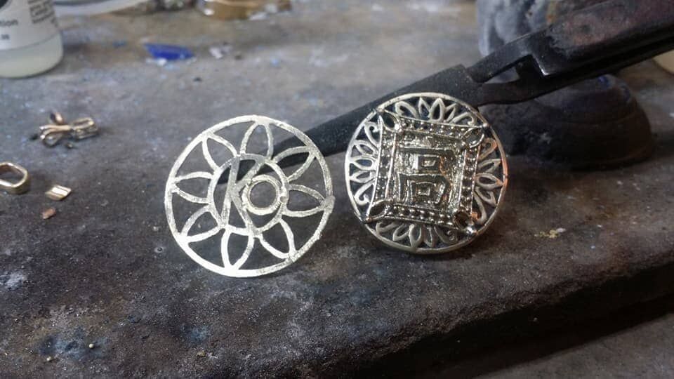 A pair of silver earrings are sitting on a table
