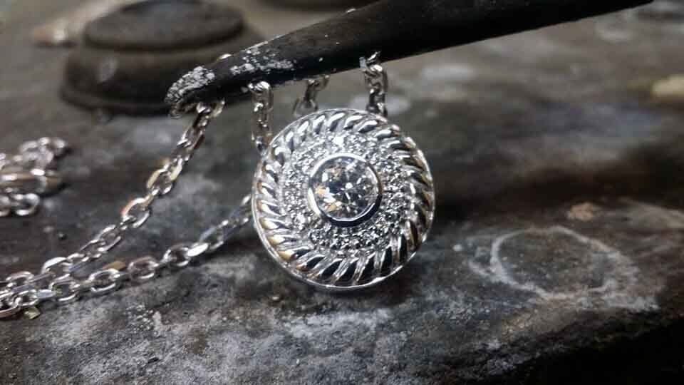 A close up of a pendant on a chain on a table