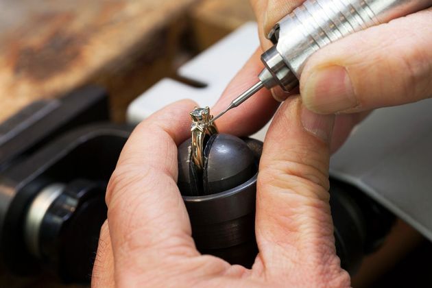 A person is working on a ring with a machine