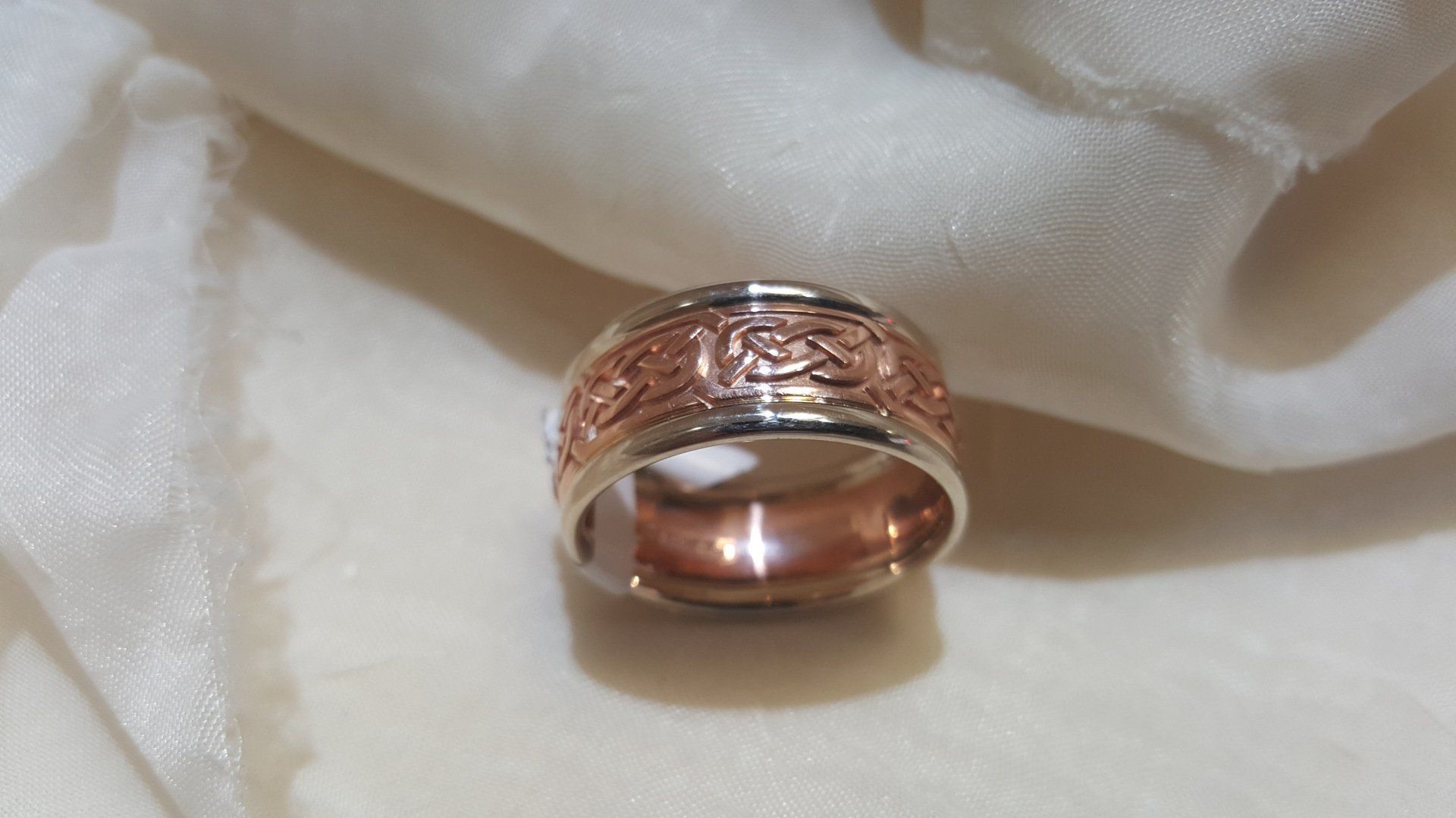 A ring is sitting on a white cloth on a table