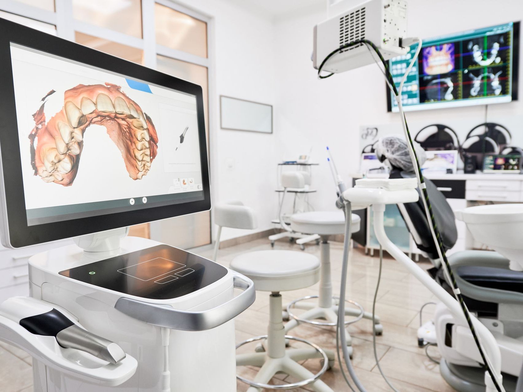 A computer monitor in a dental office with a picture of a tooth on it.