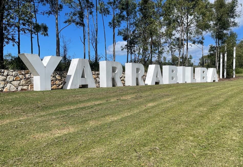 A Large Sign That Says Yarrabilla is in the Middle of a Grassy Field — Totally Skip Bins in Yarrabilba, QLD