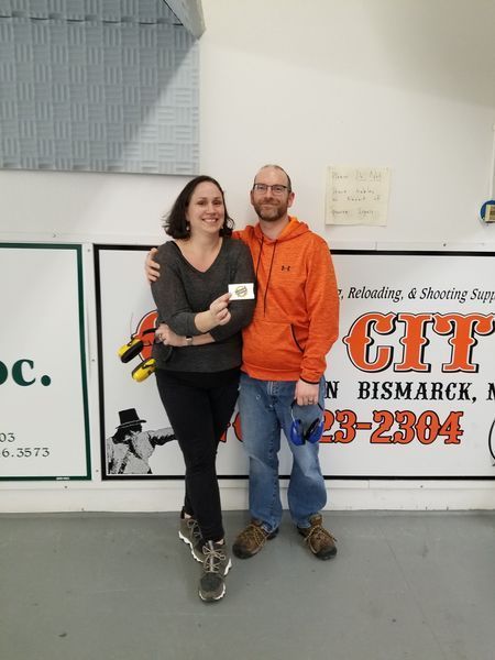 A man and a woman standing in front of a sign that says city