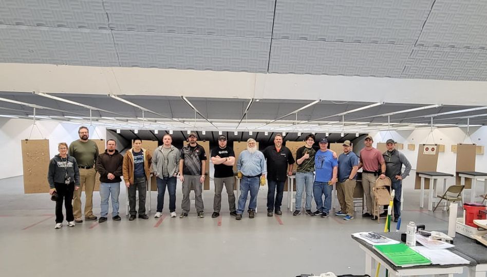 A group of people are standing in a row in a room.