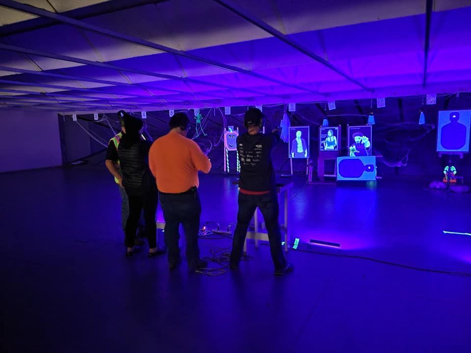 A group of men are standing in a dark room with purple lights.
