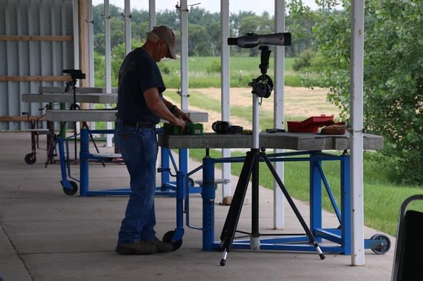 A man is standing in front of a table with a camera on it.