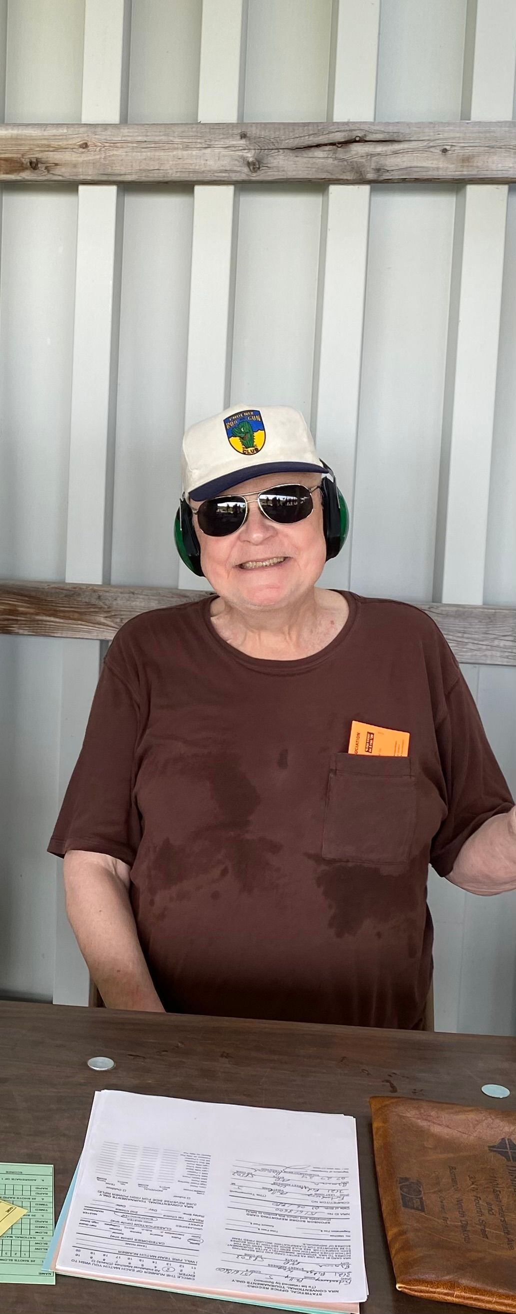 A man wearing a hat and sunglasses is sitting at a table.