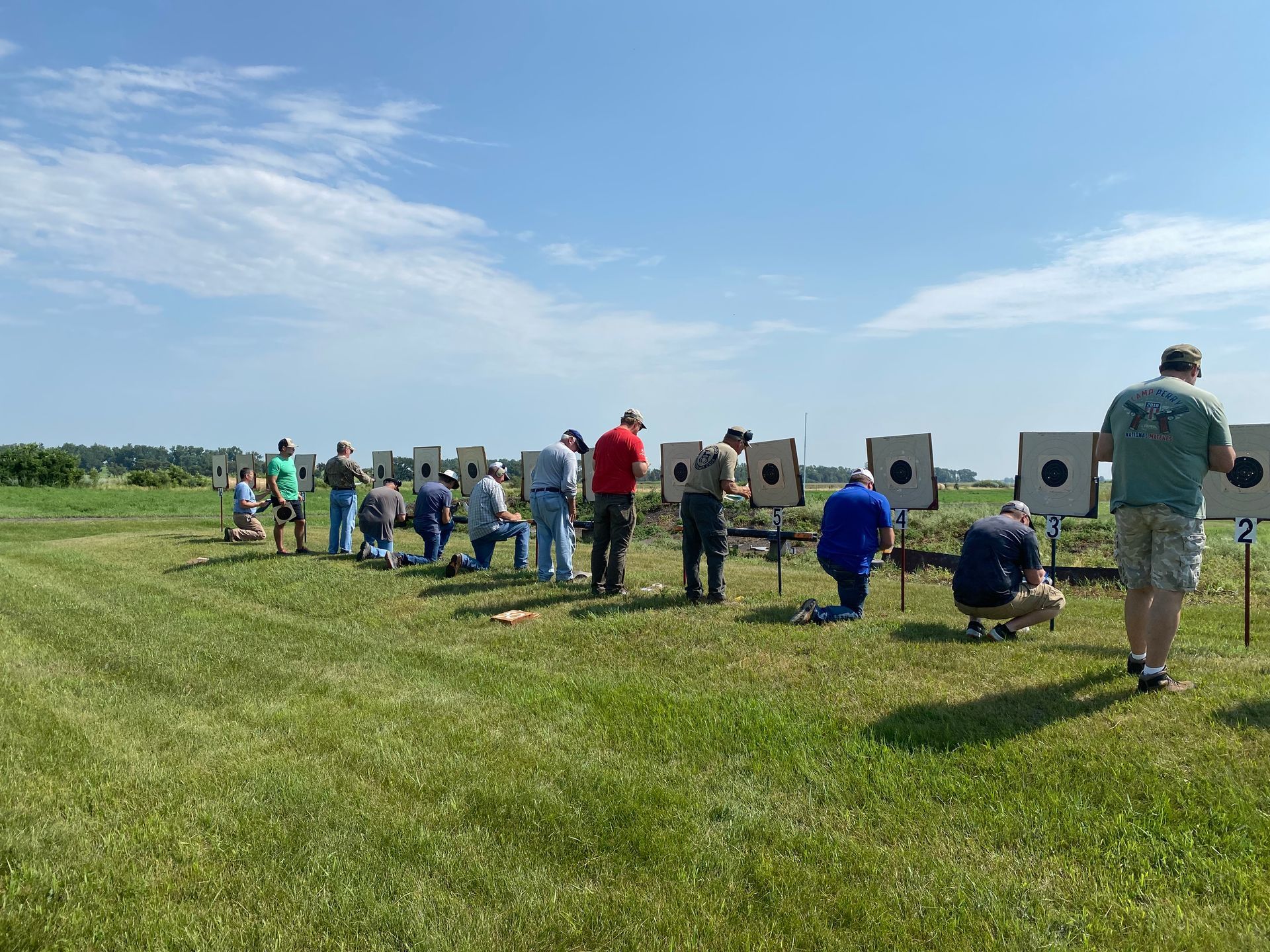 A group of people are standing in a field looking at targets.