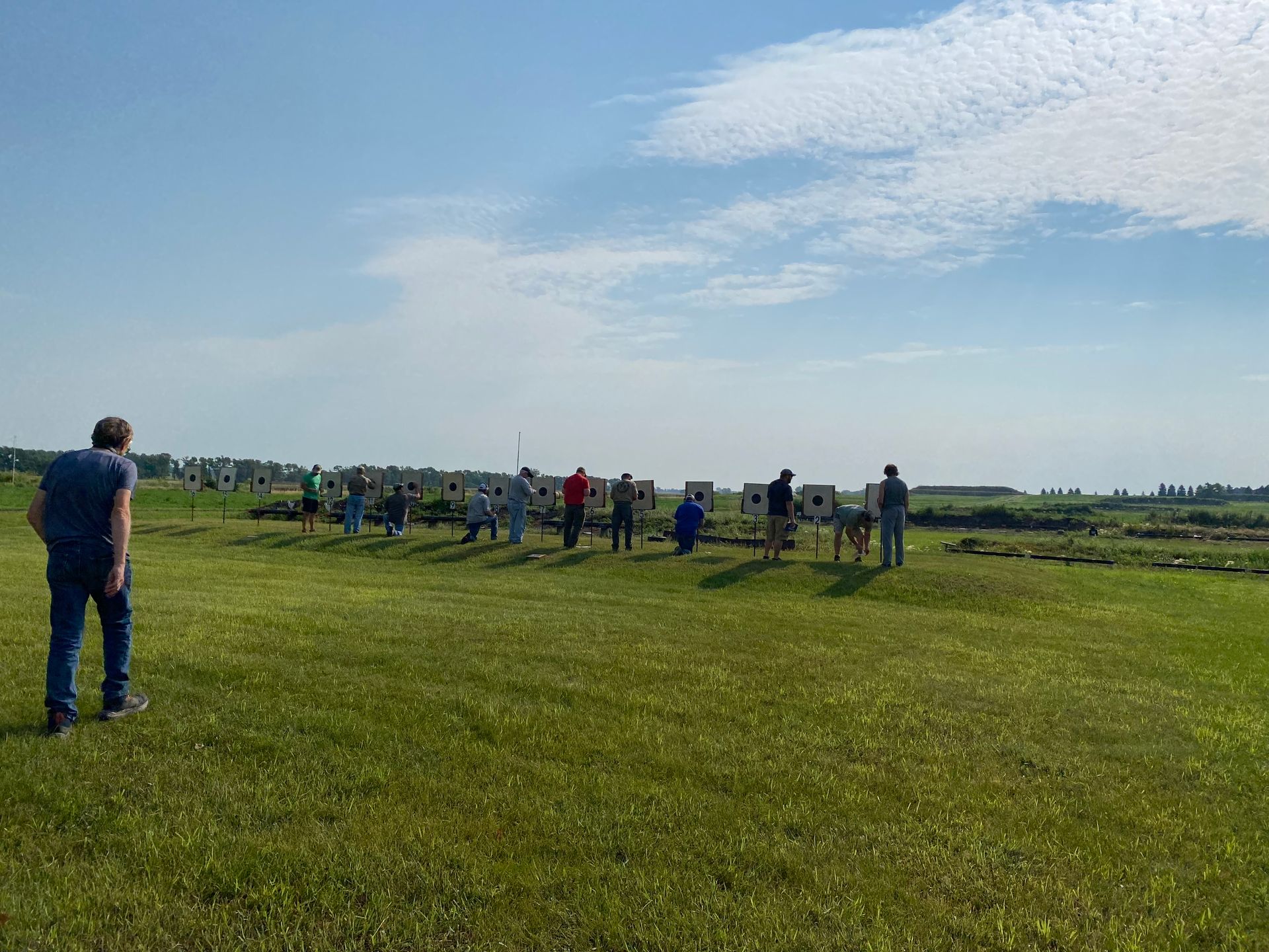 A group of people are standing in a grassy field.