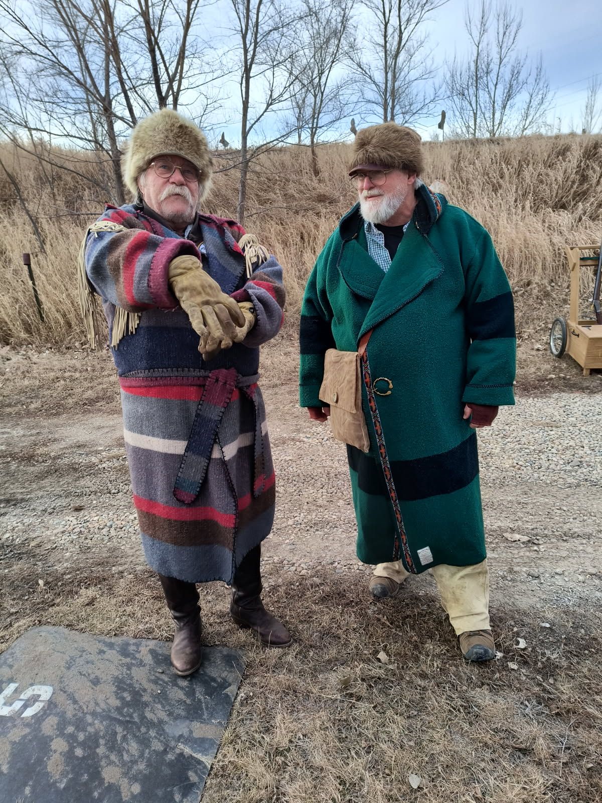Two men are standing next to each other in a field.