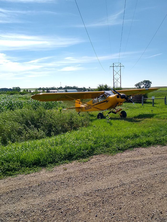 small yellow plane in an open field