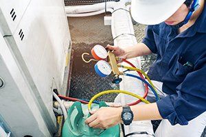 Maintenance and Repairs — Technician measuring equipment for filling air conditioners in Louisville, KY