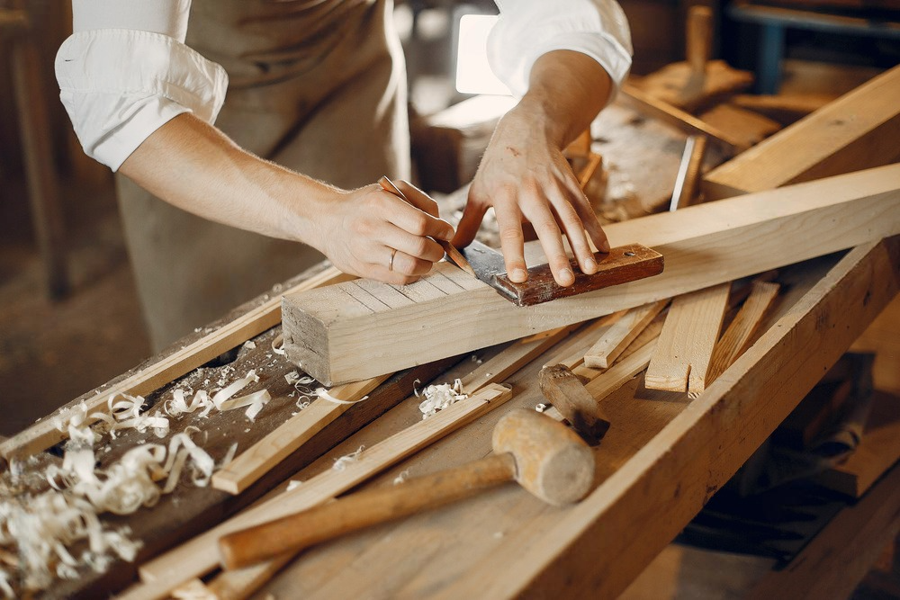 a man is measuring a piece of wood with a ruler