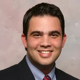 A man in a suit and tie is smiling for the camera.