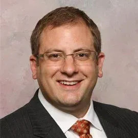 A man in a suit and tie is smiling for the camera.