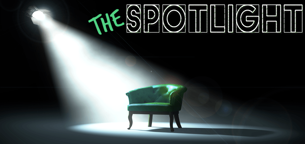 An empty green leather chair in a dark room, lit by a single spotlight.