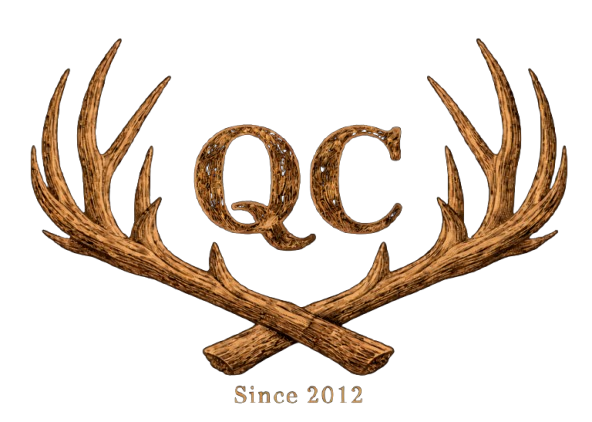 Logo with the letters "QC" in a textured brown font, framed by crossed deer antlers, with the text "Since 2012" below.