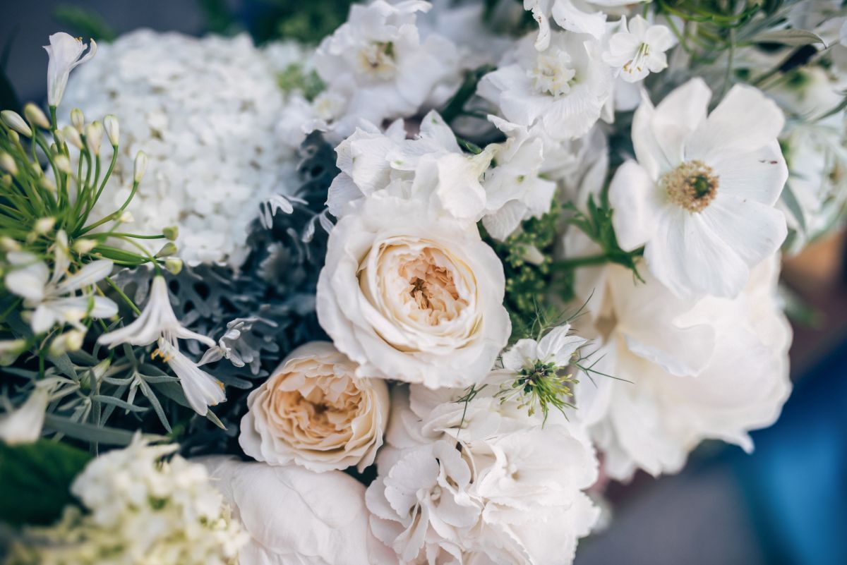 White and cream roses with greenery in a soft floral arrangement