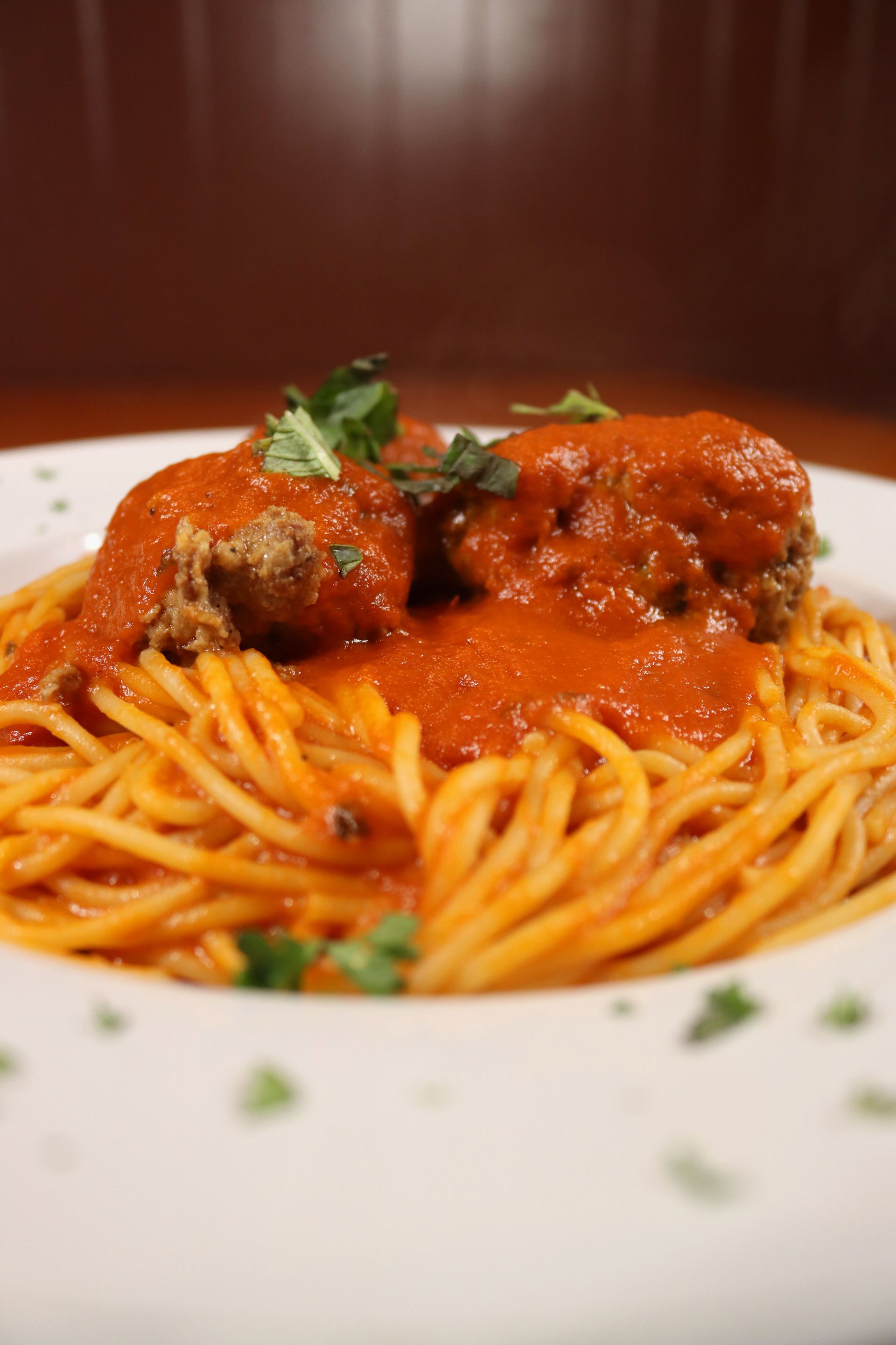A close up of a plate of spaghetti and meatballs