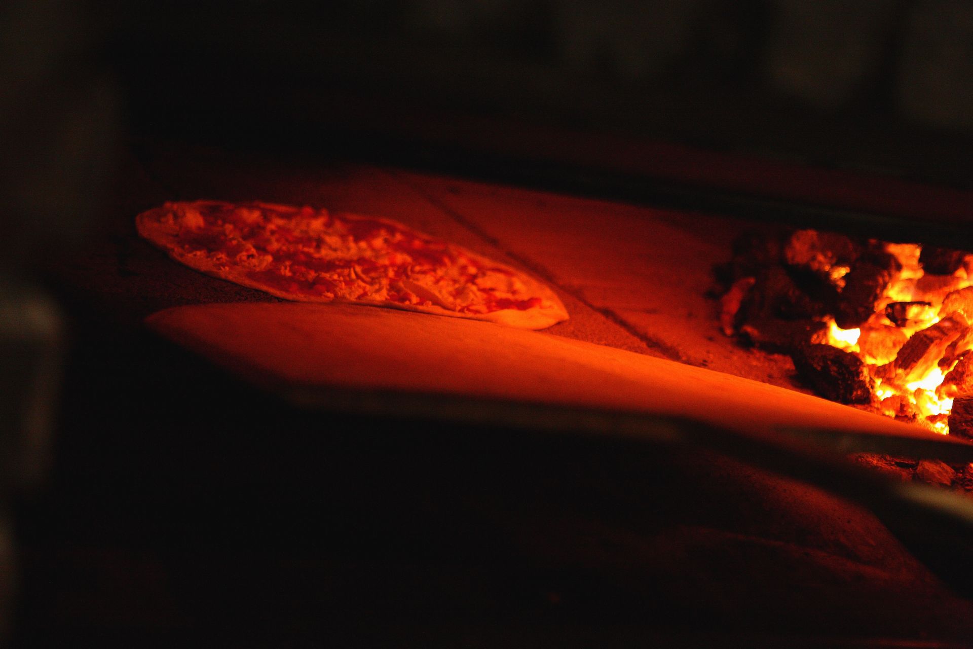 A pizza is being cooked in a pizza oven.