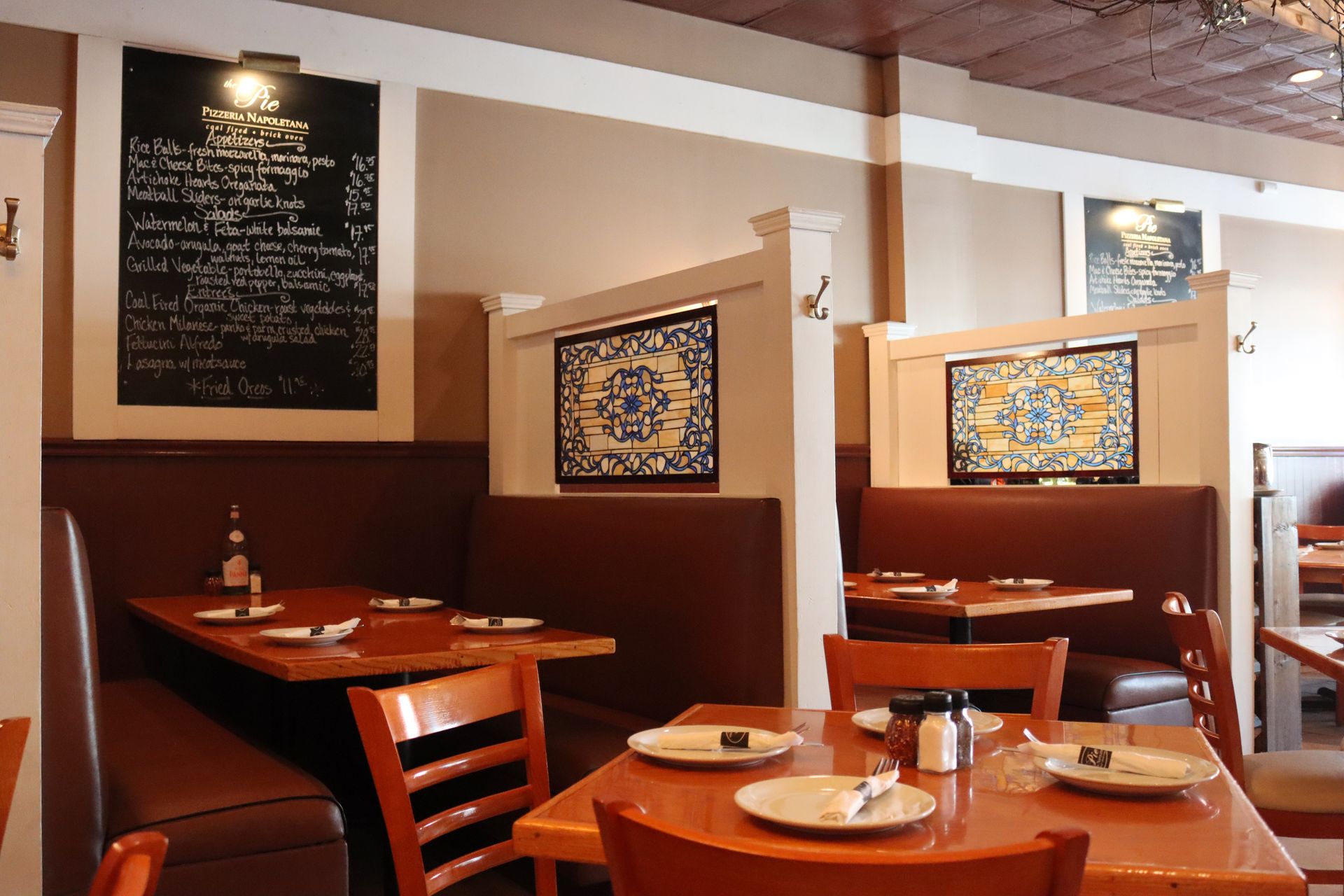 A restaurant with tables and chairs and a menu on the wall