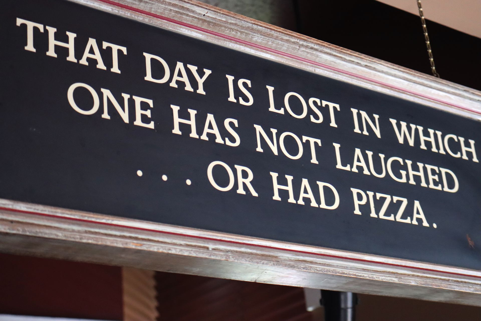A sign that says that day is lost in which one has not laughed or had pizza