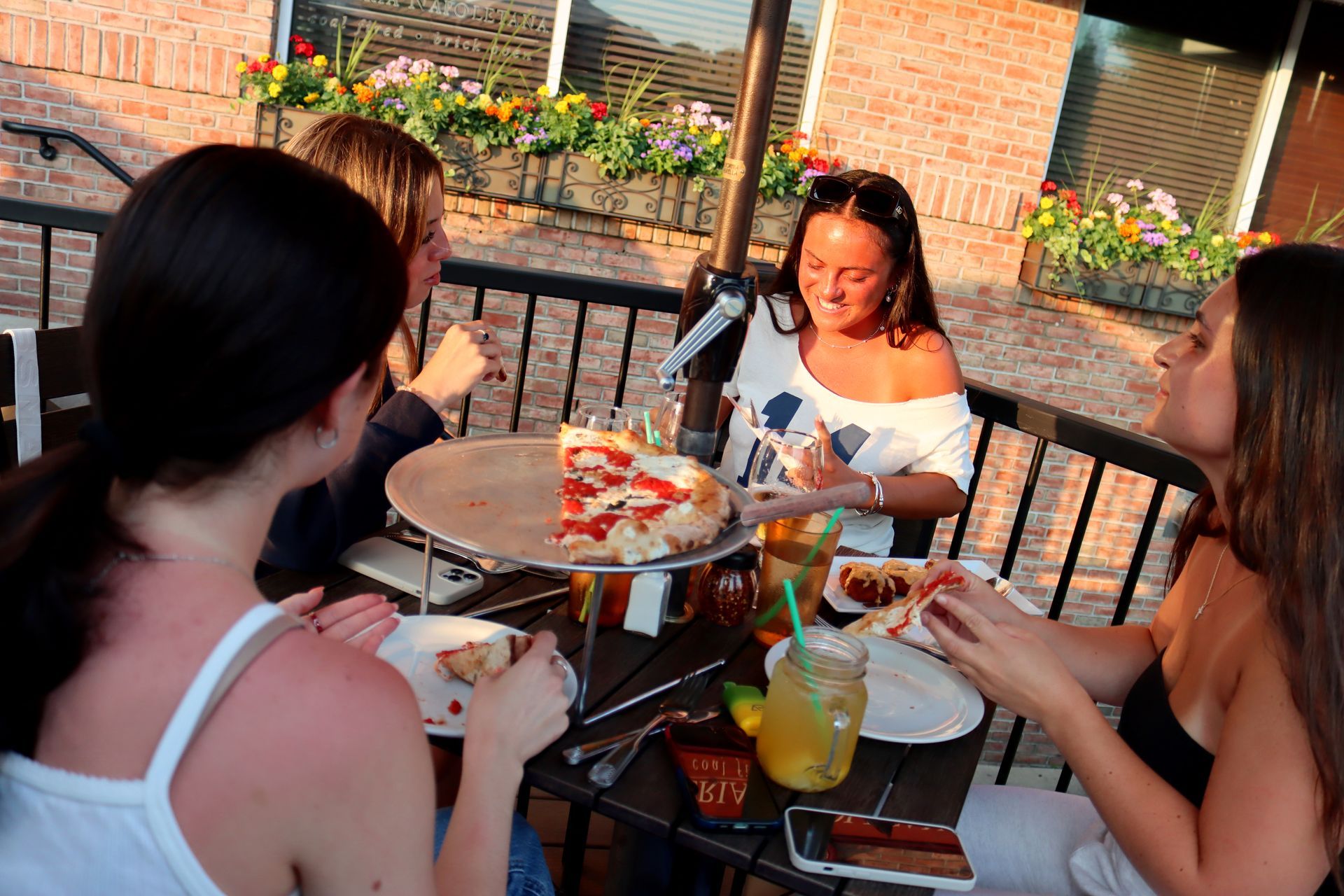 A group of women are sitting at a table eating pizza.