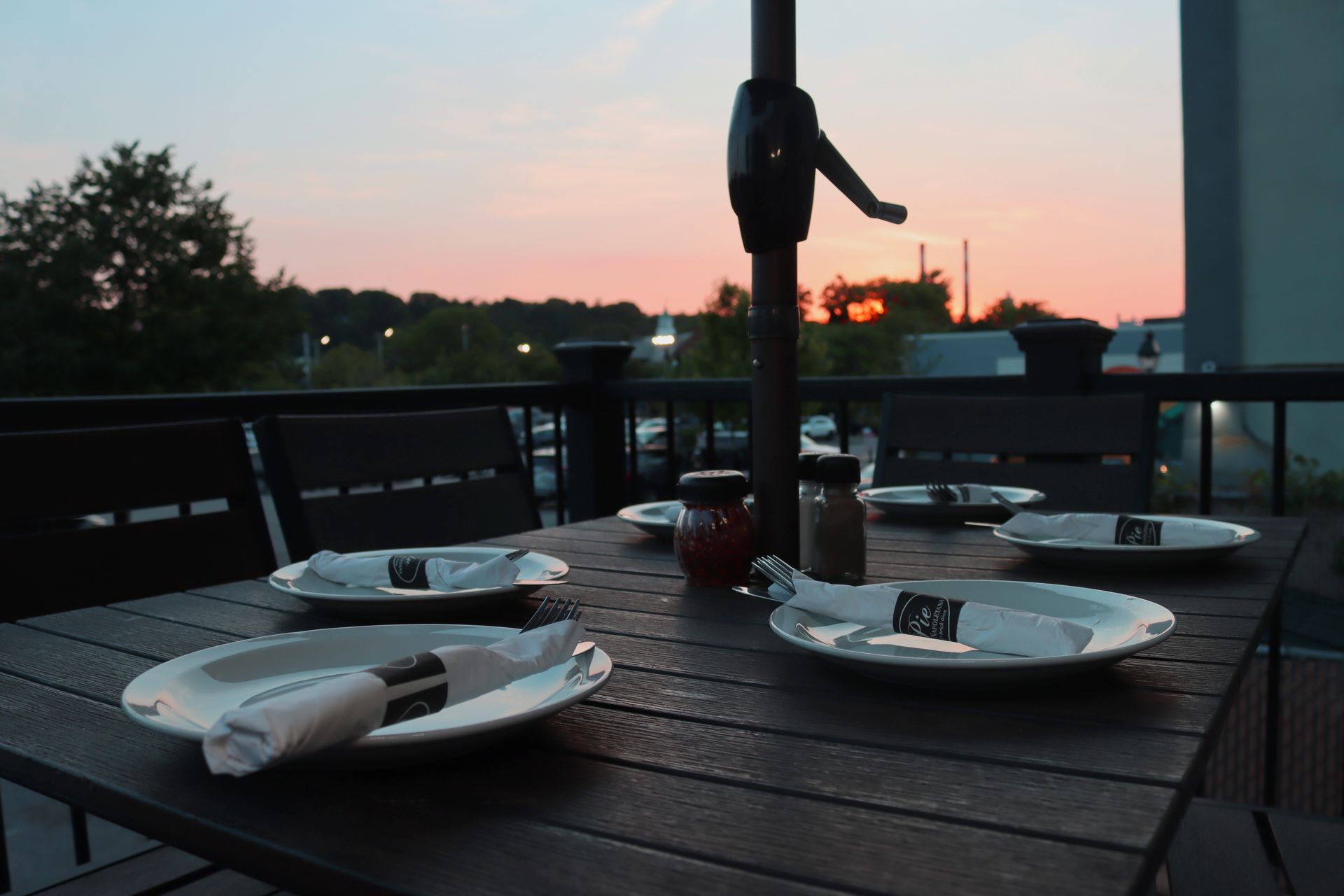 A table with plates and napkins on it with a sunset in the background