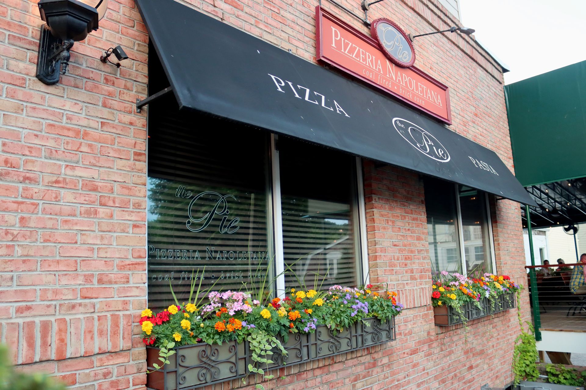 A brick building with a sign that says pizza on it