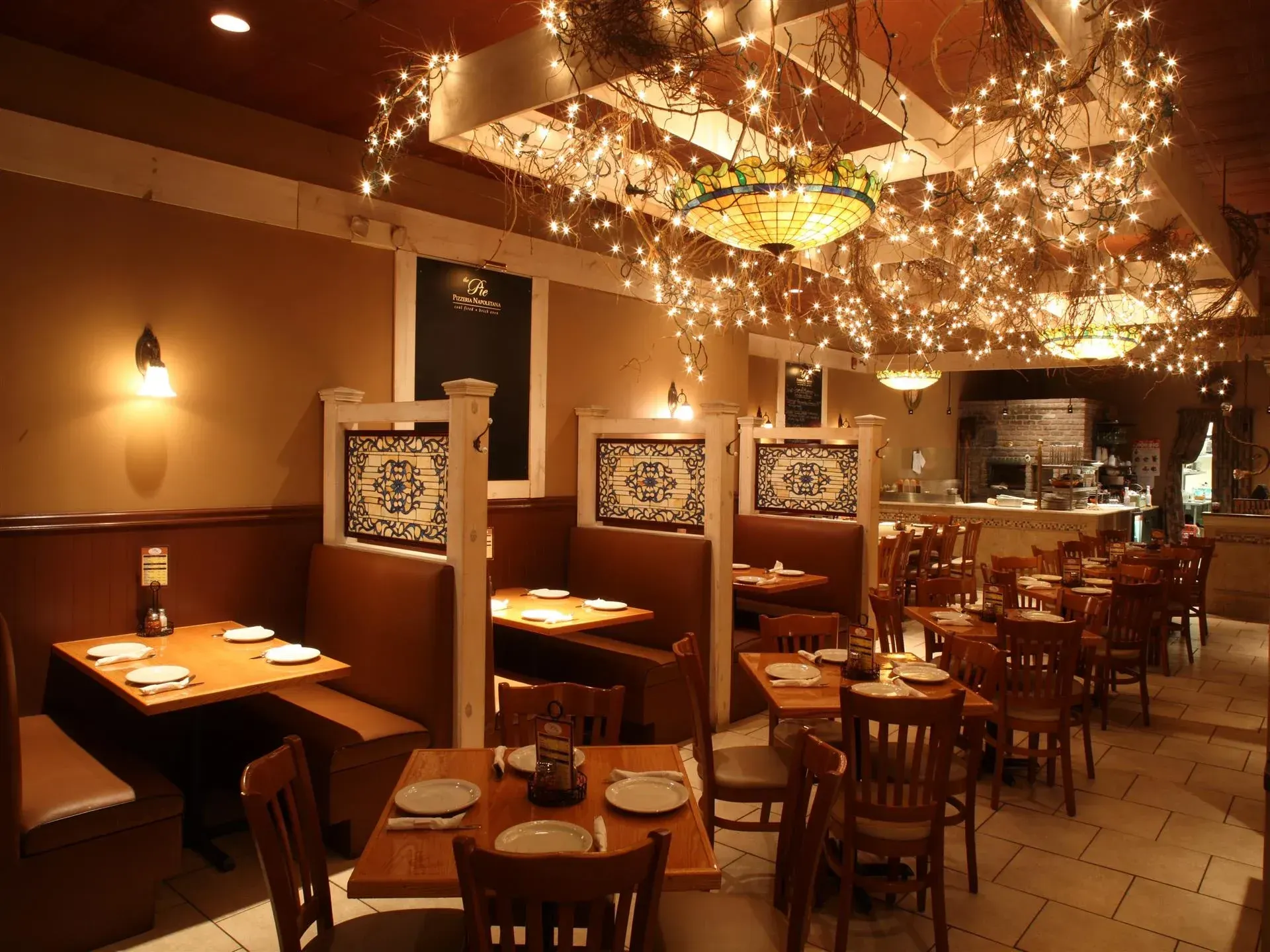 A restaurant with tables and chairs and christmas lights on the ceiling