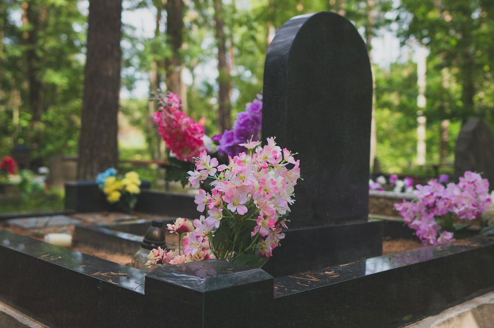 Headstone With Colourful Flowers in a Cemetery — Mid Coast Monuments In Forster, NSW