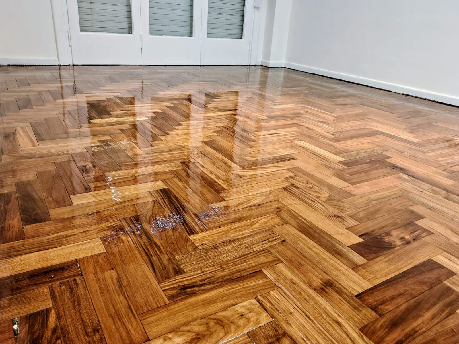 Un suelo de madera con diseño de espiga en una habitación.