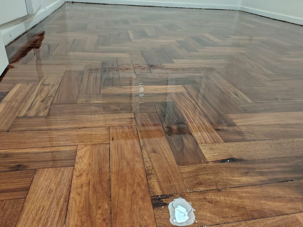 Un primer plano de un piso de madera con patrón de espiga.