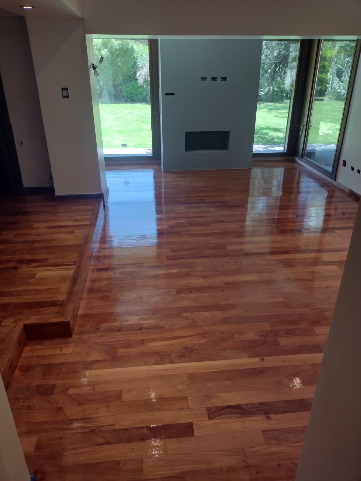 Una sala de estar con pisos de madera y chimenea.