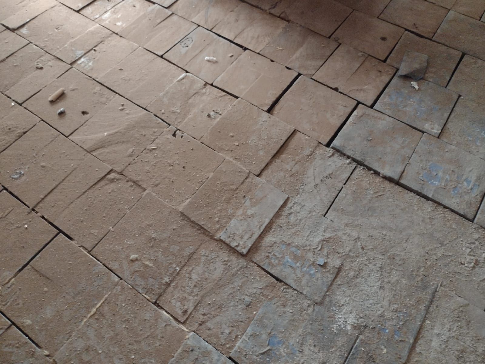 Un primer plano de un piso de ladrillo con una roca en el medio.