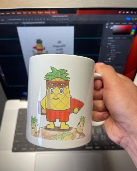 A person is holding a mug with a pineapple on it