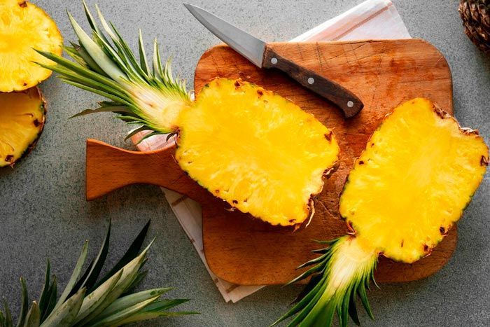 Sliced pineapple on a wood cutting board.