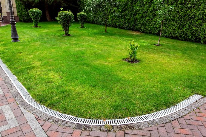 A lush green lawn with a drain in the middle of it